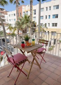 una mesa de madera y 2 sillas en el patio en Apartamento Lara, en La Herradura