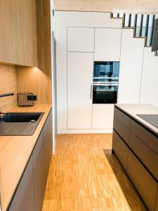 cocina con armarios blancos y suelo de madera en Sauerland Lodge - Haus Luise, en Winterberg