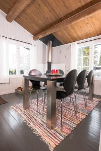 une salle à manger avec une table et des chaises sur un tapis dans l'établissement Nærglimt - cabin by the lake Næra, à Ringsaker