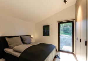 a bedroom with a bed and a large window at Sauerland Lodge - Haus X in Winterberg