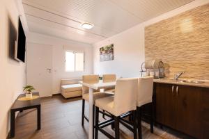 Una cocina con una mesa y sillas y un fregadero. en Apartamento Dayely, en Corralejo