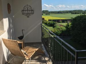 a woman sitting in a chair on a porch with a view of a field at Gemütliche und geräumige Unterkunft, Nähe Linz in Luftenberg an der Donau
