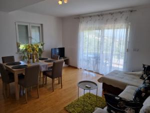 ein Wohnzimmer mit einem Tisch, Stühlen und einem Sofa in der Unterkunft Apartment Boba in Sinj