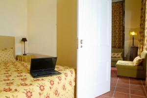 a laptop sitting on a bed in a hotel room at Casa Dos Barcos Furnas in Furnas