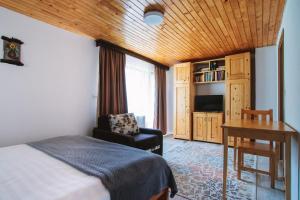 a bedroom with a bed and a chair and a desk at Pensiunea Bradet in Malaia