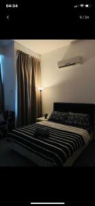 Schlafzimmer mit einem Bett mit einer schwarzen und weißen Bettdecke in der Unterkunft Furr Empire Damansara studio free netflix wifi in Petaling Jaya