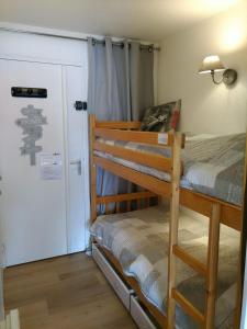 1 Schlafzimmer mit 2 Etagenbetten und einem Schrank in der Unterkunft Studio avec jardin et garage, à 100m d'une piste in Les Deux Alpes