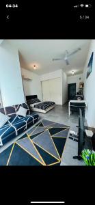 Furr Empire Damansara studio free netflix wifi في بيتالينغ جايا: غرفة معيشة بها ثلاثة أسرة وطاولة