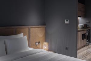 河内JAYU的卧室配有一张白色床和一张桌子上的台灯