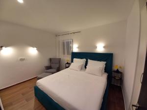 a bedroom with a large white bed and a chair at Ferma in Makarska