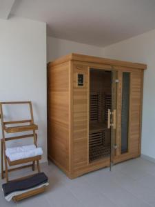um armário de madeira e uma cadeira num quarto em Thesaurum em Karanac