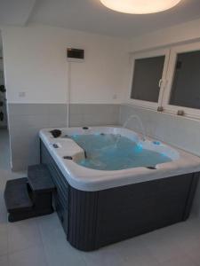 La salle de bains est pourvue d'une grande baignoire avec de l'eau bleue. dans l'établissement Thesaurum, à Karanac