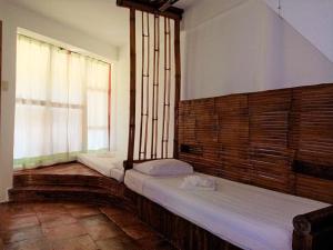 two beds in a room with a window at VILLA MARMARINE BEACH RESORT & RESTAURANT in Siquijor