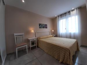 a bedroom with a bed and a chair and a window at Lo de Jaime in Arriondas