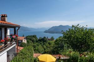 a view of a lake from a house with a yellow umbrella at LA CASA DI MONICA E LUCIANO in Stresa