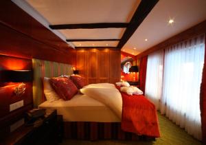 a hotel room with two beds and a large window at Resort Hotel Alex Zermatt in Zermatt