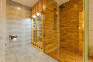 a bathroom with a shower with wood paneling at Hotel Stračena City in Ostrava