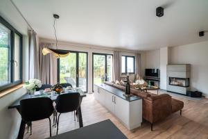 een keuken en een woonkamer met een tafel en een bank bij Hagebutte- Domizil am Ostseewald in Zingst