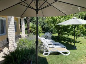 a row of lounge chairs and an umbrella at Apartment Iris in Portorož