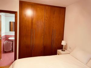 a bedroom with a wooden cabinet and a bed at Playa Nigrán in Nigrán