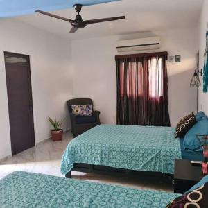 1 dormitorio con 2 camas y 1 silla en Apartamento Africa, en Palenque
