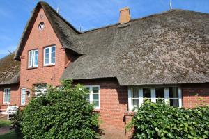 una casa in mattoni rossi con tetto di paglia di Ohl Doerp 22 Pastoratshof_ Haus 3 a Wrixum