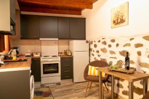 eine Küche mit weißen Geräten und einem Holztisch in der Unterkunft Anemolia Tiny Stone House in Palekastro