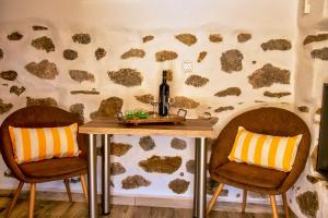 una mesa y dos sillas con una botella de vino. en Anemolia Tiny Stone House, en Palaikastro