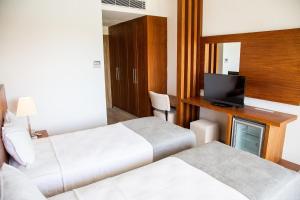 A bed or beds in a room at Casa De Playa Luxury Hotel & Beach