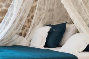 a bed with blue and white pillows and a canopy at Holiday Home Godinj in Donje Rašćane