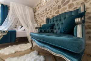 a blue couch in a room with a bed at Holiday Home Godinj in Donje Rašćane