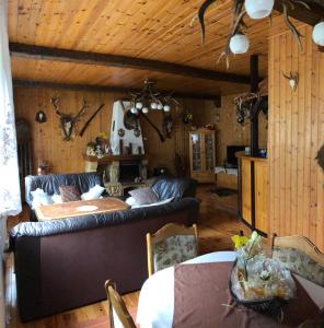 ein Wohnzimmer mit einem Sofa und einem Tisch in der Unterkunft Złoty Kłos in Szklarska Poręba