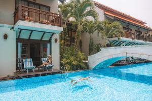 Eine Frau, die in einem Pool in einem Hotel schwimmt. in der Unterkunft Khaolak Oriental Resort - Adult Only in Khao Lak