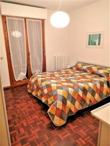 1 dormitorio con 1 cama con una manta colorida en Appartamento OLEANDRO a Fano tra centro e mare vicino ospedale, en Fano
