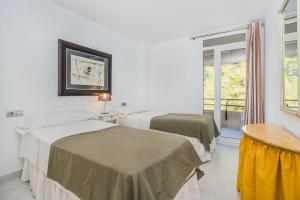 a hotel room with two beds and a window at Apartment Lord Jim By SunVillas Mallorca in Port de Pollensa