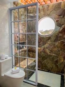 a bathroom with a stone wall and a toilet at Morelo Water Villa in Batam Center