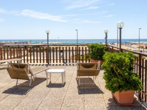 - un balcon avec 2 chaises, une table et la plage dans l'établissement Hotel Turandot, à Torre del Lago Puccini