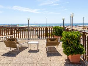 a balcony with two chairs and a table and the beach at Hotel Turandot in Torre del Lago Puccini