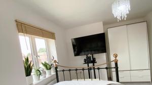 a bedroom with a bed and a flat screen tv at Entire home: Bicester Village 10min walk (650m) in Bicester