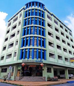 a large white building with blue windows at Perfectroom Mansion in Hat Yai