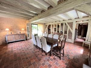 une salle à manger avec une table et des chaises blanches dans l'établissement Cottage authentique avec piscine, à Prunay-Cassereau