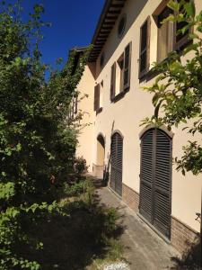 Casa blanca con ventanas con persianas negras y árboles en il passero, en Costa