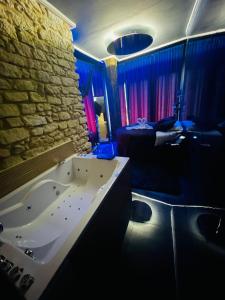a bathroom with a tub and a bedroom with a bed at Utopía Alicante - Adults Experience in Alicante
