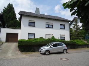 a small car parked in front of a white house at Fewo Lena in Welling