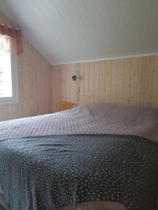 a bedroom with a large bed with a blue comforter at Suvantorinne 