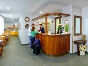 een groep mensen die aan een bar in een restaurant staan bij Hotel Melantrich in Praag