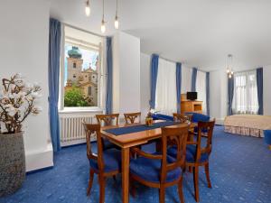 a dining room with a table and chairs and a bedroom at Hotel Melantrich in Prague