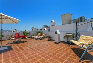 patio z krzesłami, stołem i parasolem w obiekcie El rincon de lola in nerja w mieście Nerja