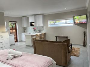 uma cozinha e sala de estar com uma cama num quarto em Luneburgh Cottages em East London