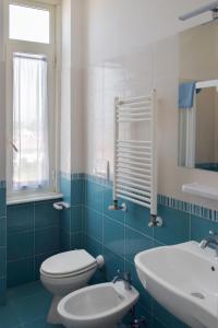 a blue and white bathroom with a toilet and a sink at Hotel Il Caravaggio in Marina di Pietrasanta